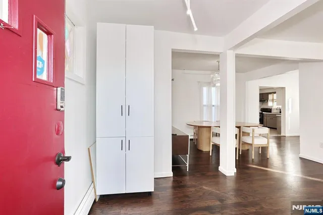a view of an empty room with wooden floor and a large window