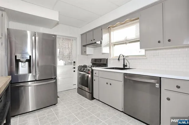 a kitchen with a refrigerator sink and cabinets
