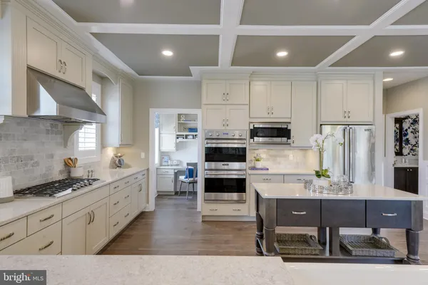 a large kitchen with kitchen island a large counter top space appliances and cabinets