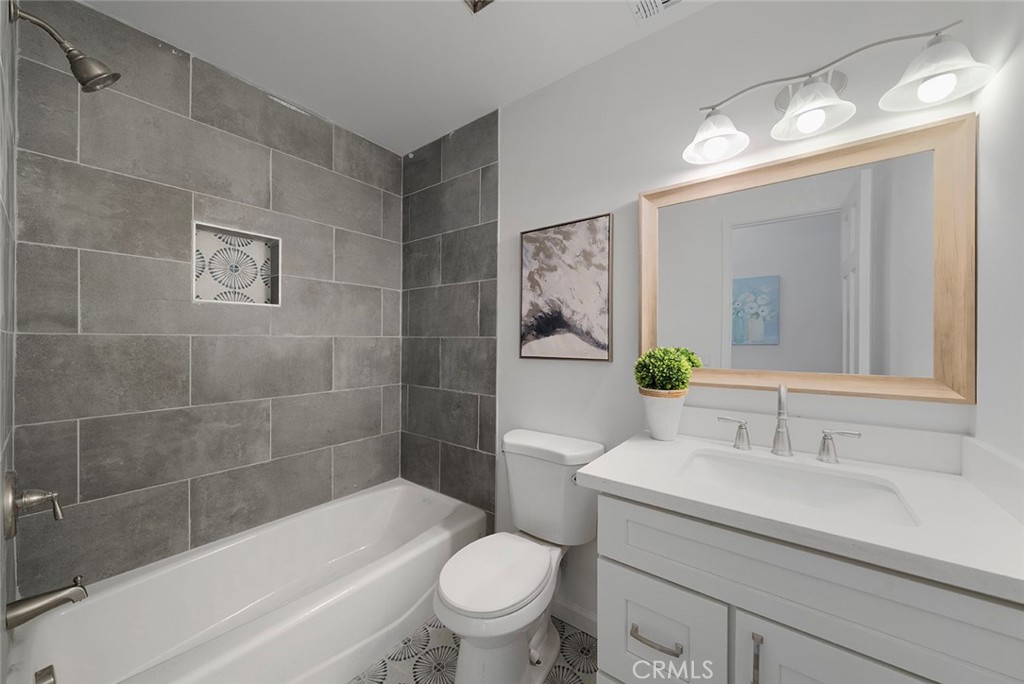 917 Renee Street Redlands, CA 92374 - Photo 16 of 26 Newly updated hallway bathroom with cast iron tub, stylish tile, fixtures, cabinet, sink, toilet.