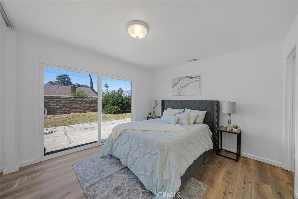 917 Renee Street Redlands, CA 92374 - Photo 17 of 26 Primary bedroom updated with flooring, paint, lighting, double pane slider to the backyard.