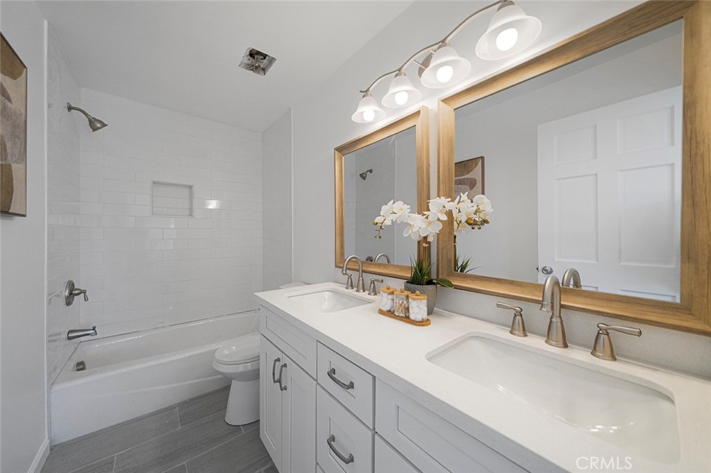 917 Renee Street Redlands, CA 92374 - Photo 19 of 26 Reimagined primary bathroom newly updated that now has double sinks along with new cabinet, fixtures, mirror, counter, cast iron tub, tile.