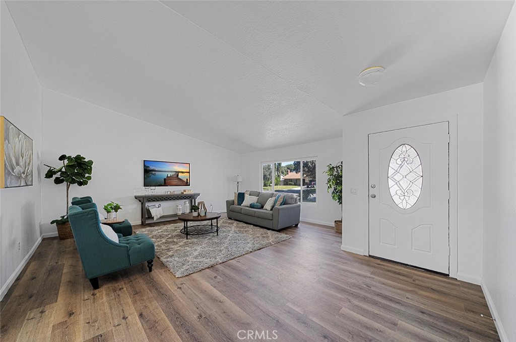 917 Renee Street Redlands, CA 92374 - Photo 4 of 26 Entry opens to the spacious living room with newer vinyl plank flooring and double pane windows and high ceilings.
