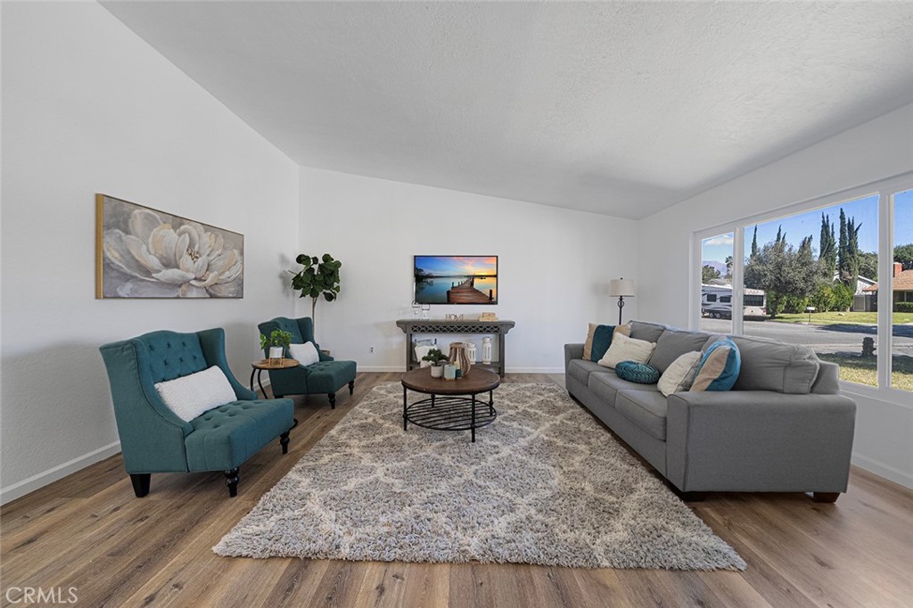 917 Renee Street Redlands, CA 92374 - Photo 5 of 26 Spacious living room with newer luxury vinyl plank flooring. Newly painted and newer double pane flooring. Ceiling height gets to about 10 feet.