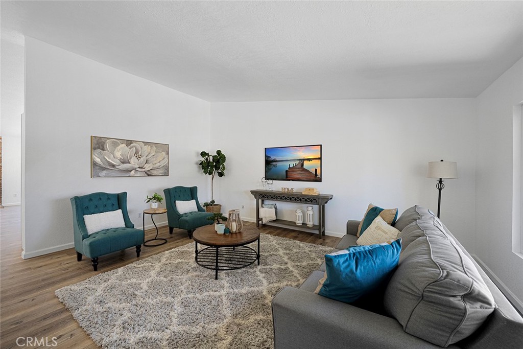 917 Renee Street Redlands, CA 92374 - Photo 6 of 26 Spacious living room with newer luxury vinyl plank flooring. Newly painted and newer double pane flooring. Ceiling height gets to about 10 feet.