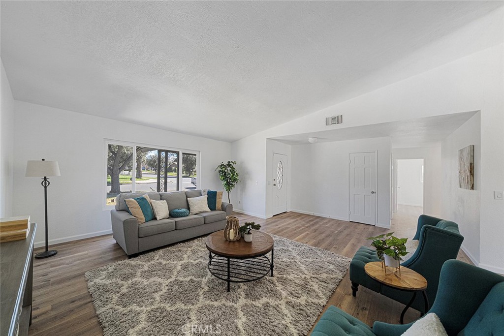917 Renee Street Redlands, CA 92374 - Photo 8 of 26 Spacious living room with newer luxury vinyl plank flooring. Newly painted and newer double pane flooring. Ceiling height gets to about 10 feet.