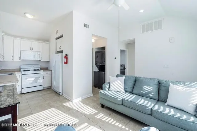 a living room with furniture and kitchen view