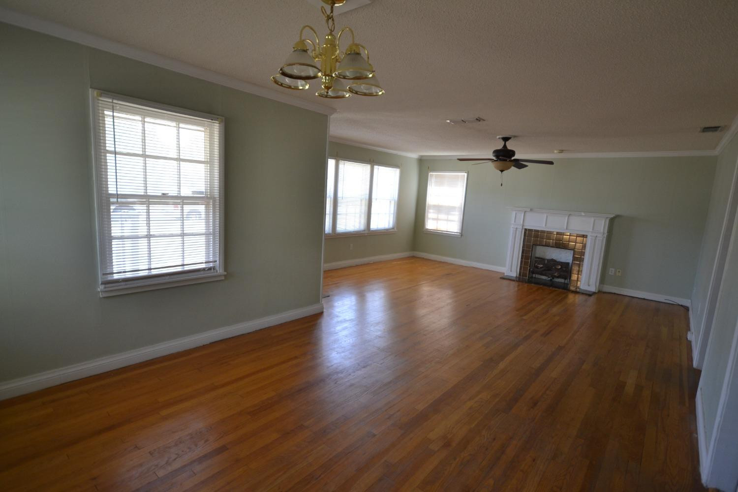 2611 31st Street Lubbock, TX 79410 - Photo 2 of 15 a view of empty room with wooden floor and fan