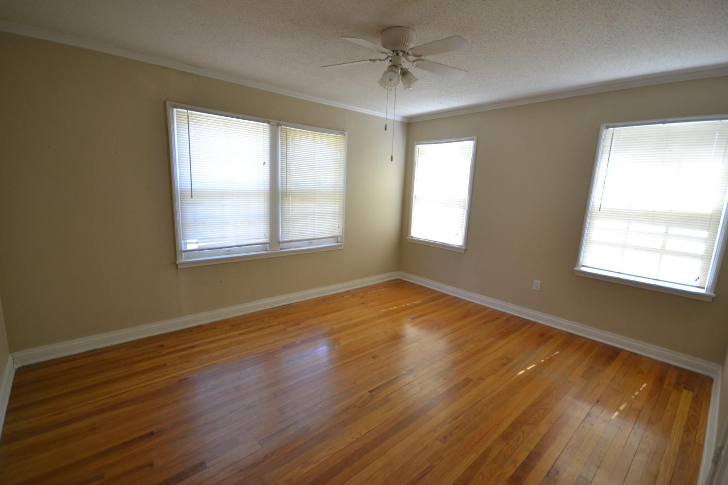 2611 31st Street Lubbock, TX 79410 - Photo 3 of 15 a view of an empty room with wooden floor and a window