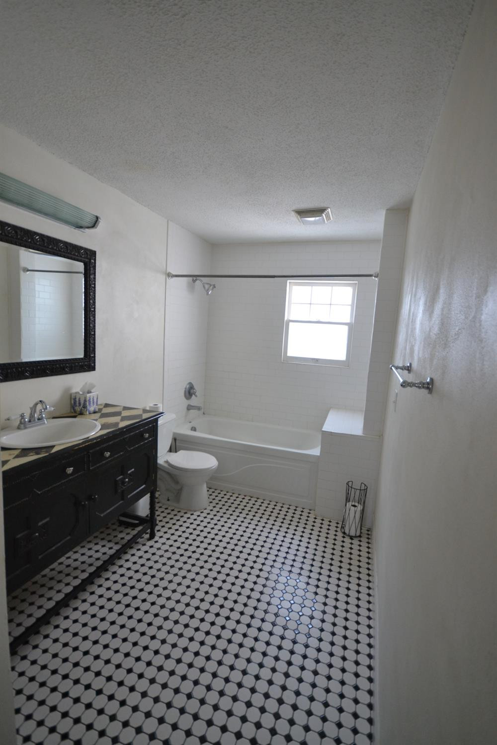 2611 31st Street Lubbock, TX 79410 - Photo 4 of 15 a bathroom with a sink a toilet and mirror