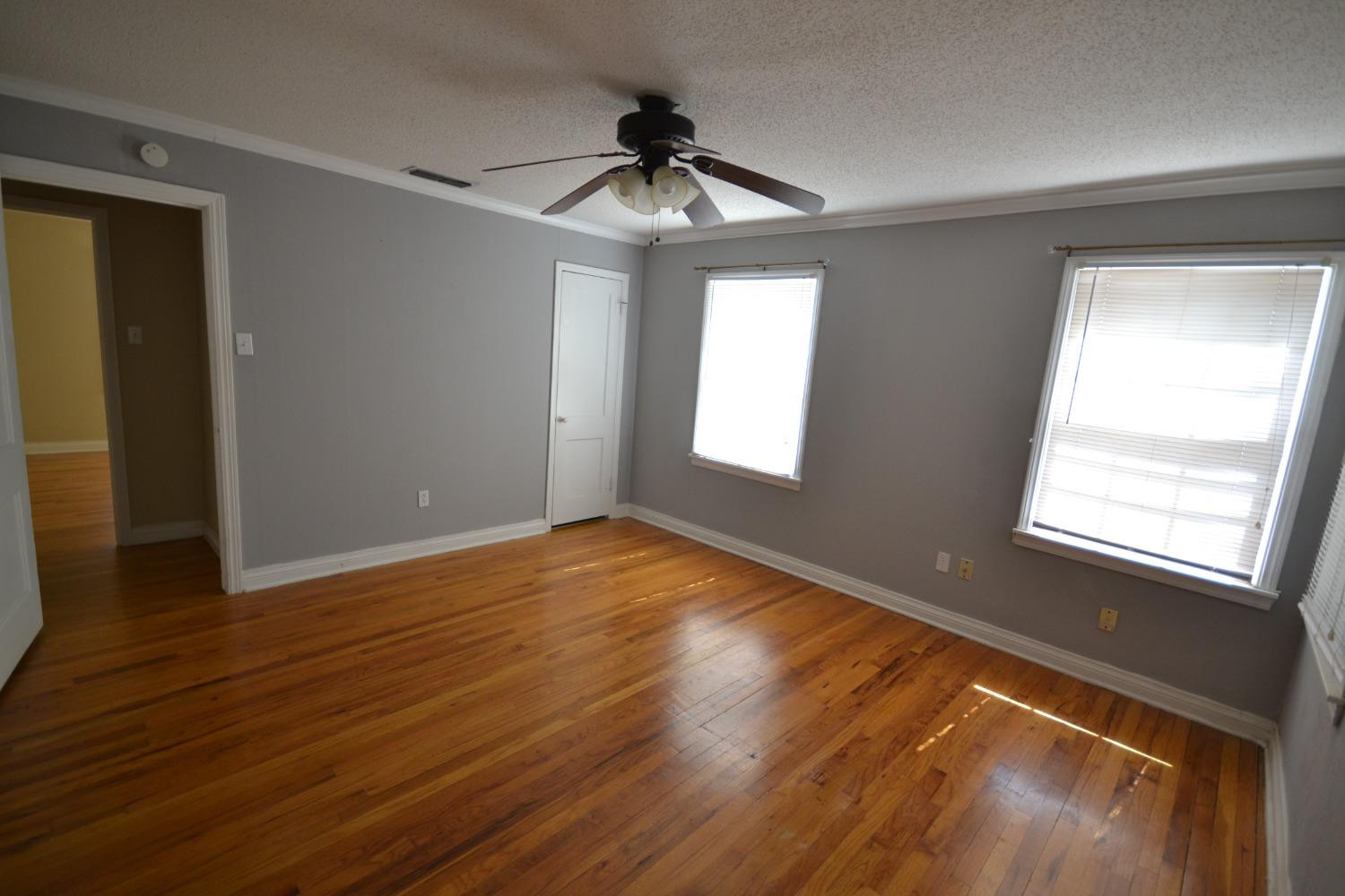 2611 31st Street Lubbock, TX 79410 - Photo 8 of 15 a view of an empty room with wooden floor and a window