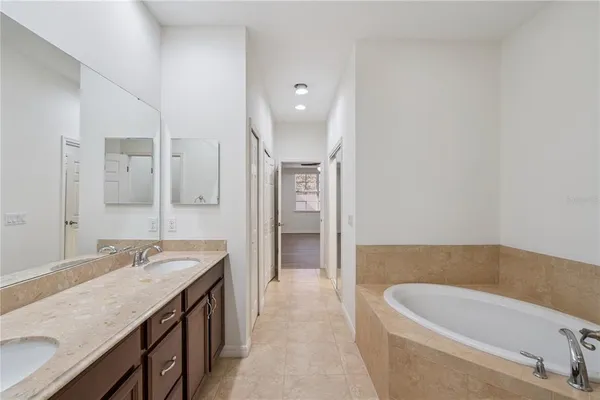 a bathroom with a tub a sink and mirrors