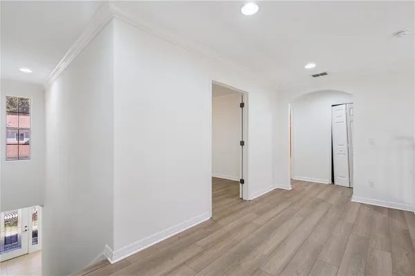 a view of an empty room with wooden floor