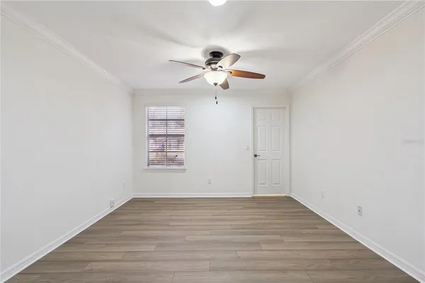 a view of a room with wooden floor and a ceiling fan