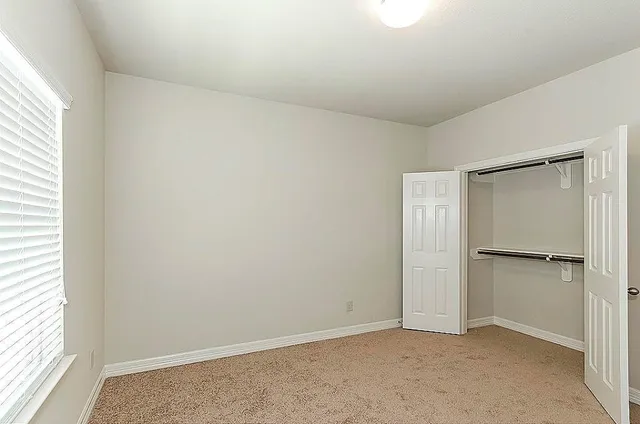 an empty room with closet and a window