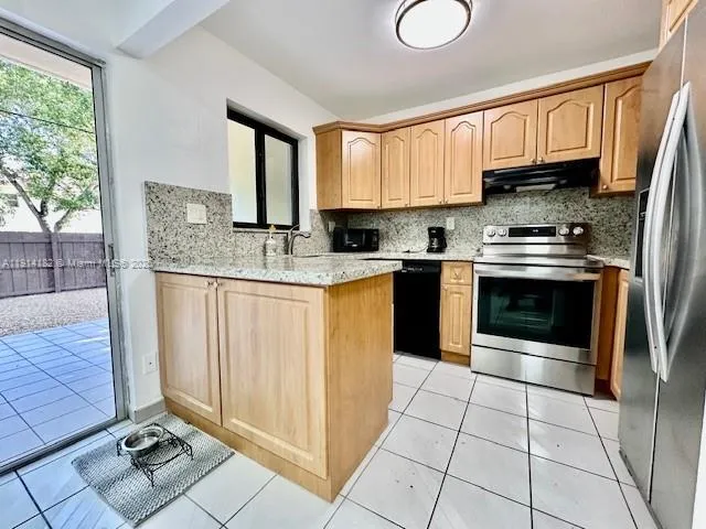 a kitchen with stainless steel appliances granite countertop a stove sink and cabinets