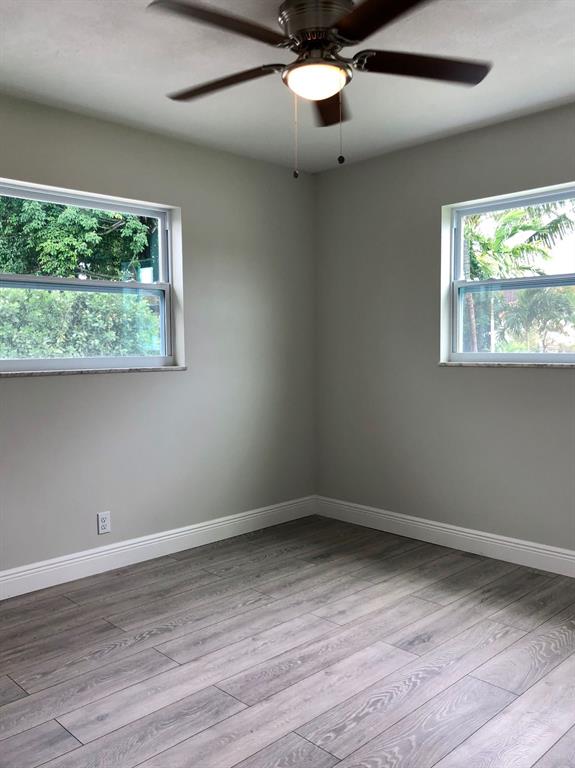 3980 Northwest 109th Avenue Coral Springs, FL 33065 - Photo 9 of 12 an empty room with wooden floor and windows