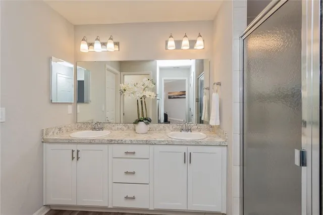 a bathroom with a granite countertop sink vanity and mirror