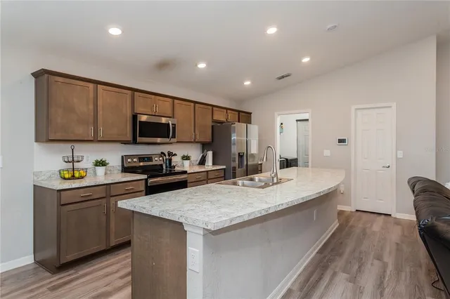 a kitchen with sink a microwave and cabinets