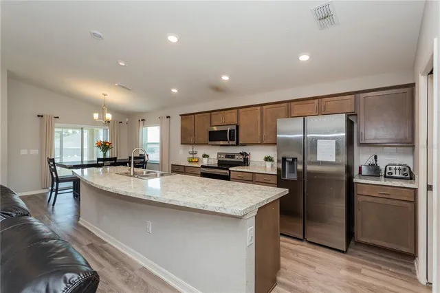 a large kitchen with stainless steel appliances lots of counter space and breakfast area