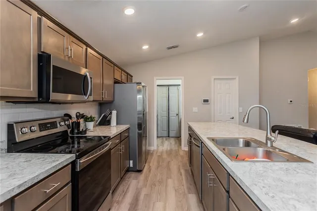 a kitchen with stainless steel appliances granite countertop a sink stove and refrigerator