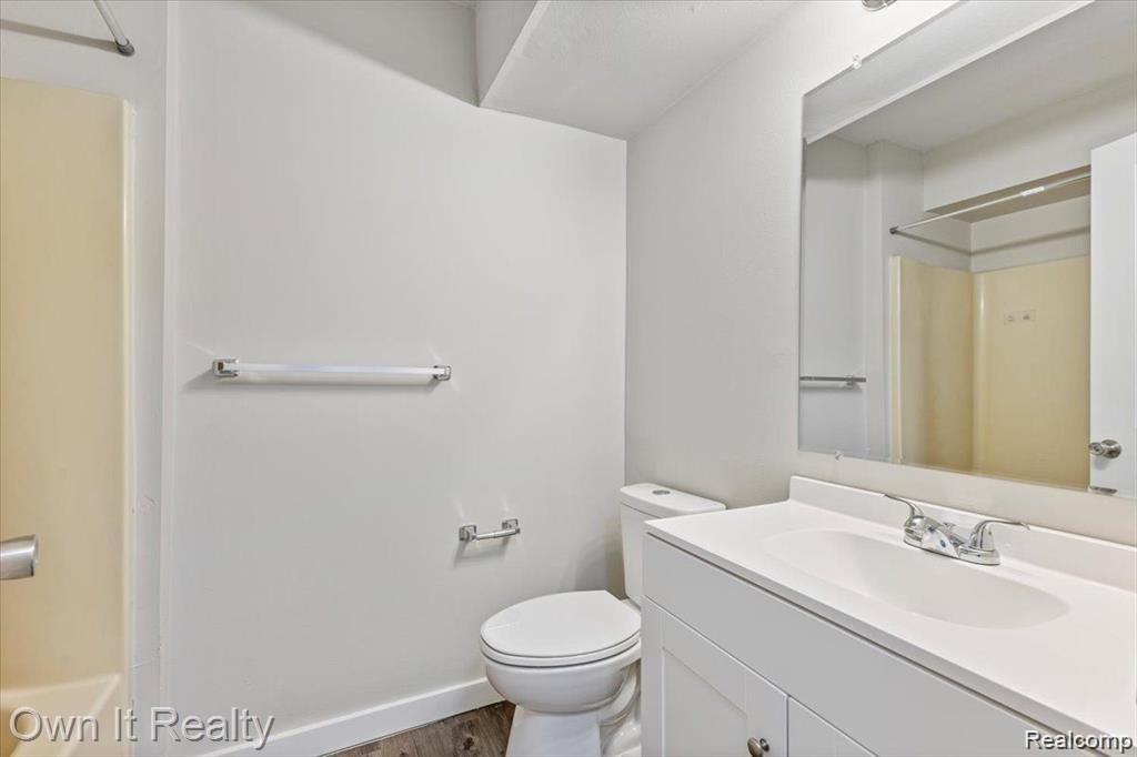 59314 Van Dyke Road Washington, MI 48094 - Photo 10 of 16 Bathroom featuring vanity, wood finished floors, and shower combination
