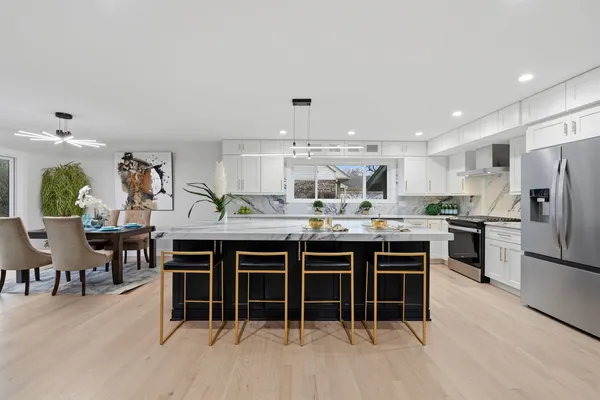 a kitchen with stainless steel appliances a dining table chairs and granite counter tops