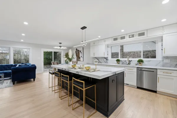 a kitchen with kitchen island granite countertop a sink and a stove top oven
