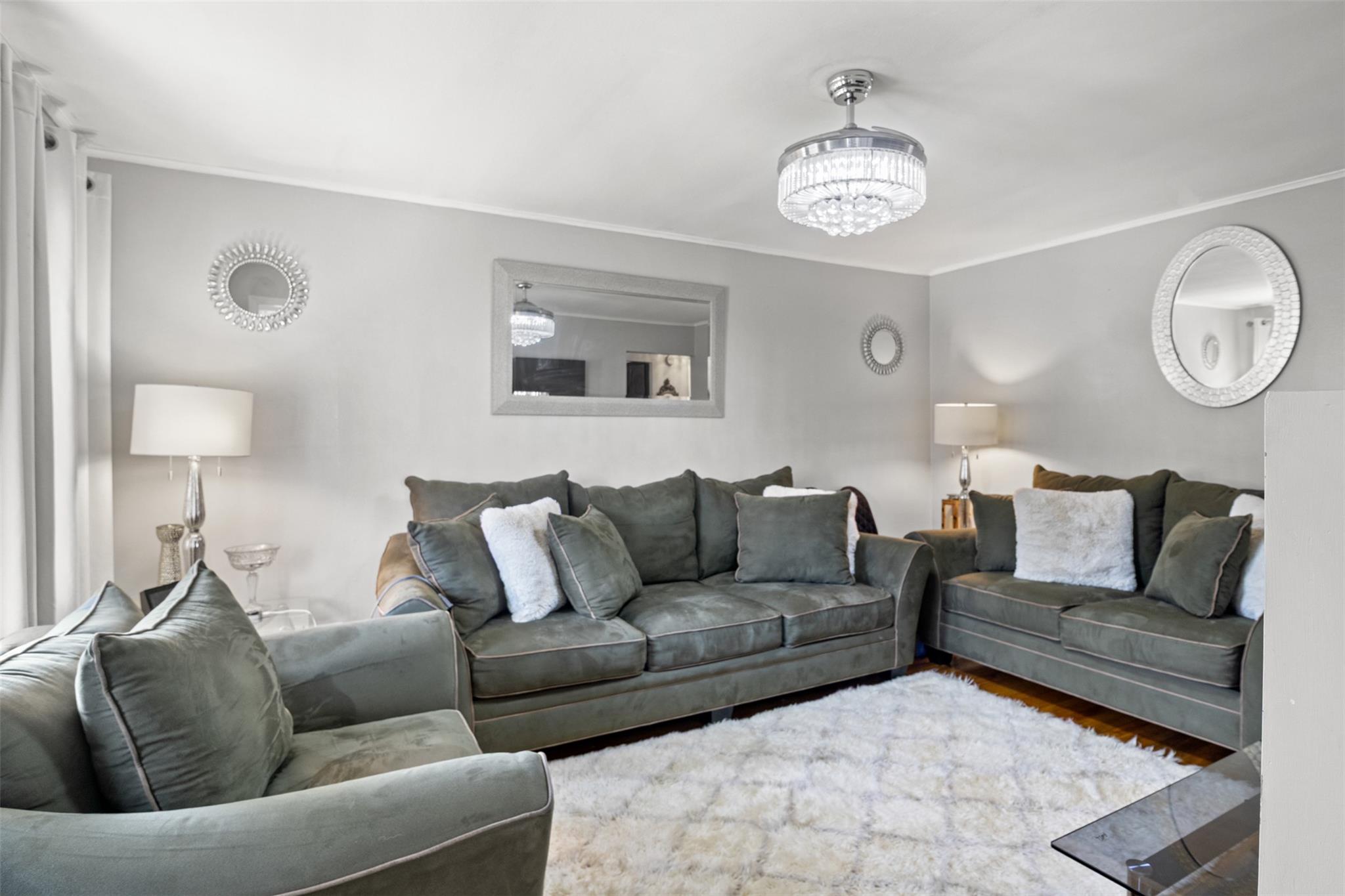 239-15 147th Road Queens, NY 11422 - Photo 11 of 27 a living room with furniture a clock and a window