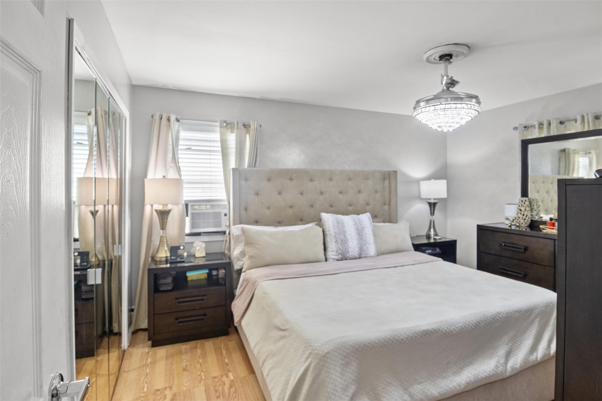 239-15 147th Road Queens, NY 11422 - Photo 14 of 27 a bed room with a bed and a chandelier