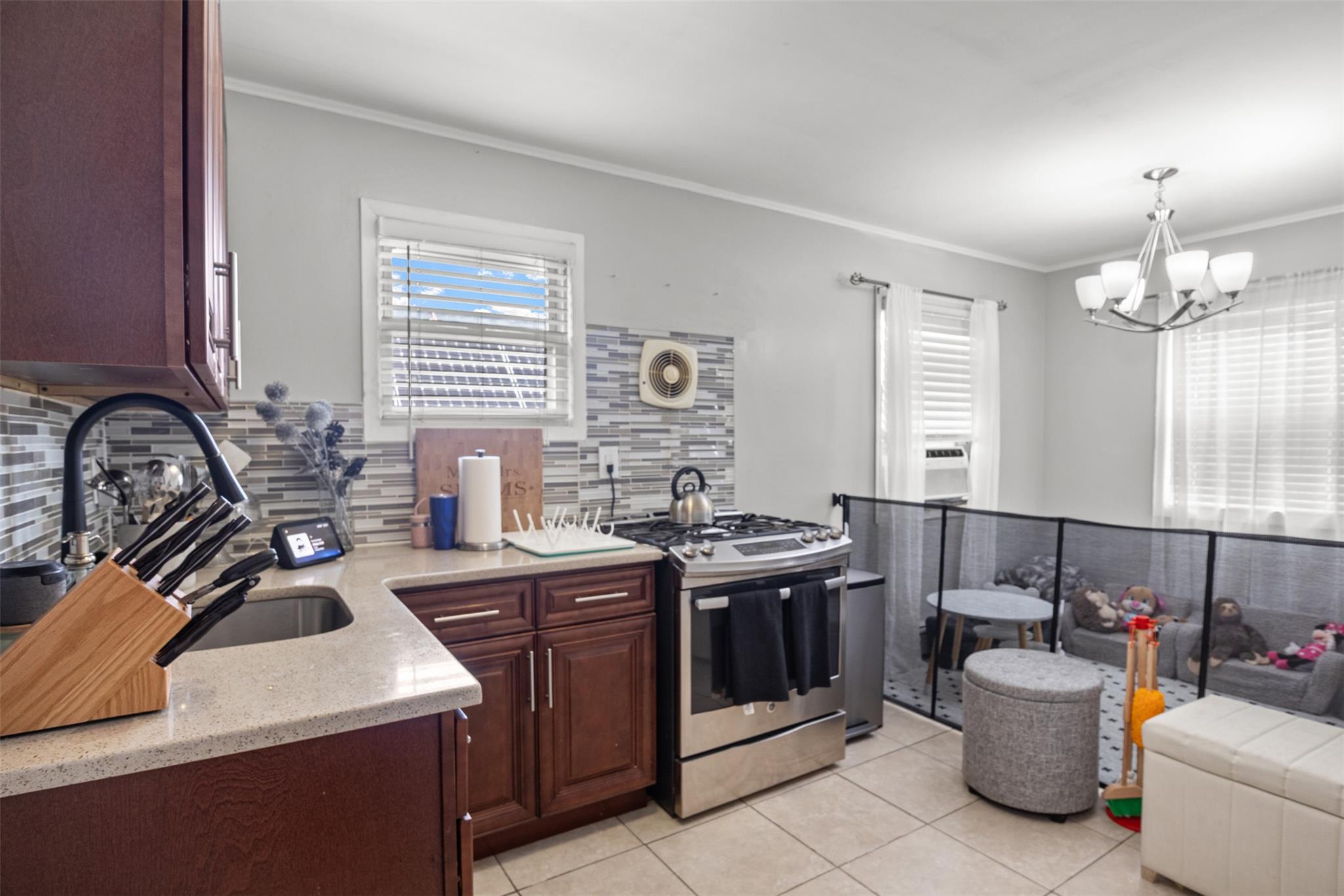 239-15 147th Road Queens, NY 11422 - Photo 18 of 27 a kitchen with a stove a sink and a refrigerator