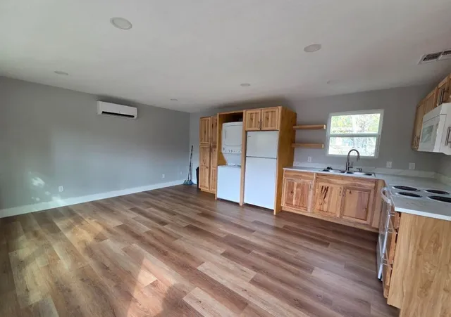 a kitchen with granite countertop a refrigerator and a stove top oven