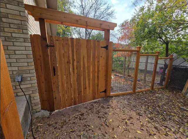 a view of a backyard with wooden fence and large trees
