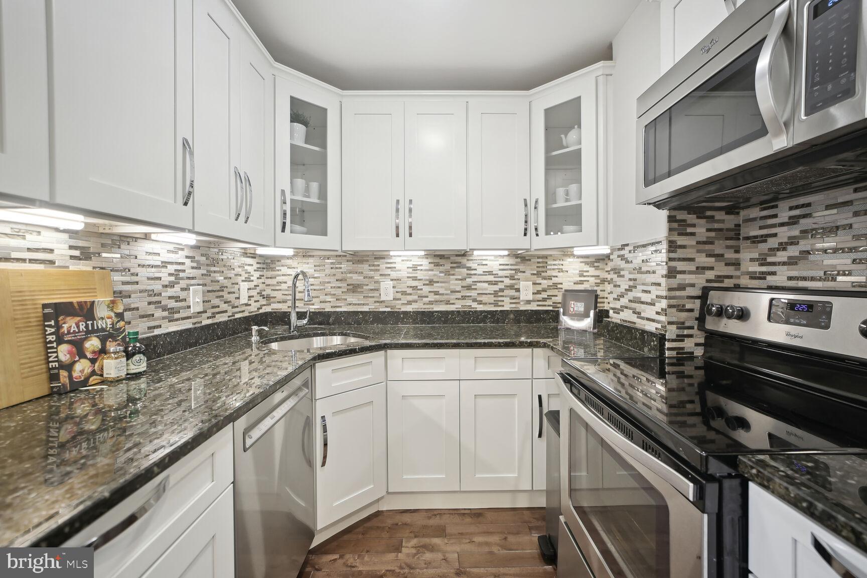 1451 Park Road Northwest, Unit 113 Washington, DC 20010 - Photo 13 of 50 a kitchen with stainless steel appliances granite countertop a sink stove and cabinets