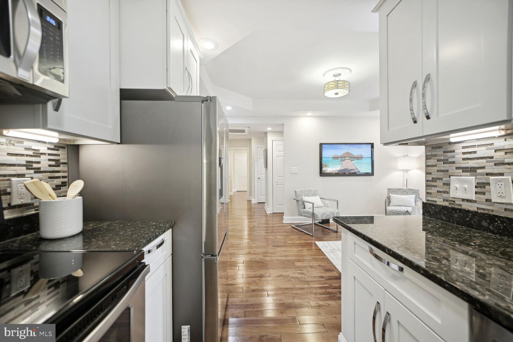 1451 Park Road Northwest, Unit 113 Washington, DC 20010 - Photo 15 of 50 a kitchen with stainless steel appliances granite countertop a sink stove and refrigerator