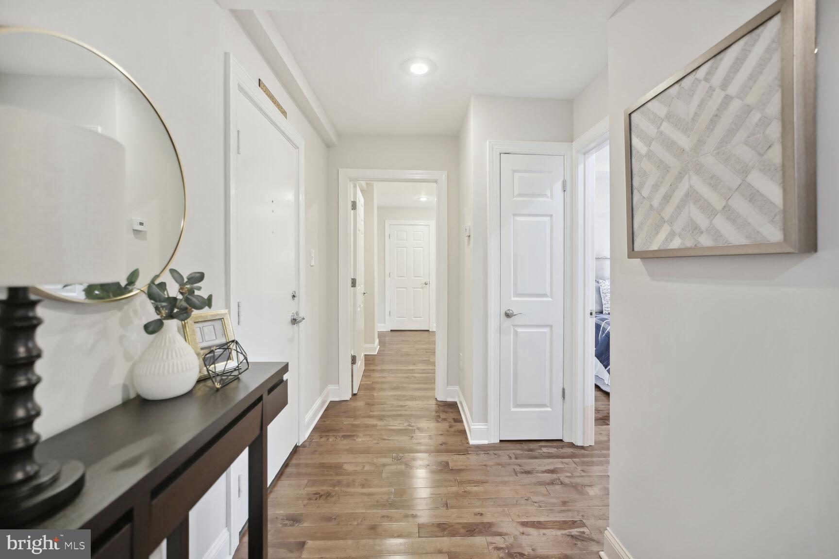 1451 Park Road Northwest, Unit 113 Washington, DC 20010 - Photo 4 of 50 a hallway with a view of bedroom with wooden floor