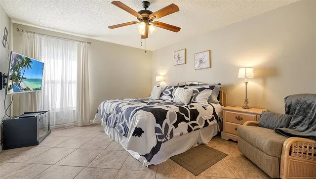 a spacious bedroom with a bed and ceiling fan
