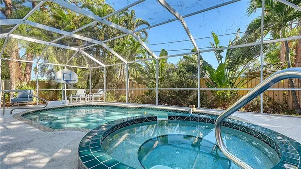 a view of a swimming pool with a patio and wooden fence