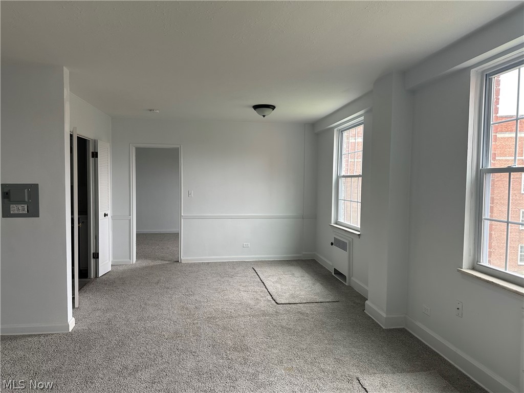 13800 Fairhill Road, Unit 416 Shaker Heights, OH 44120 - Photo 5 of 13 Spacious room featuring new carpeting, fresh white paint, two large windows, and classic wainscoting