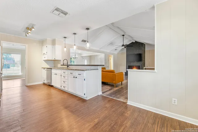 a kitchen with a sink cabinets and wooden floor