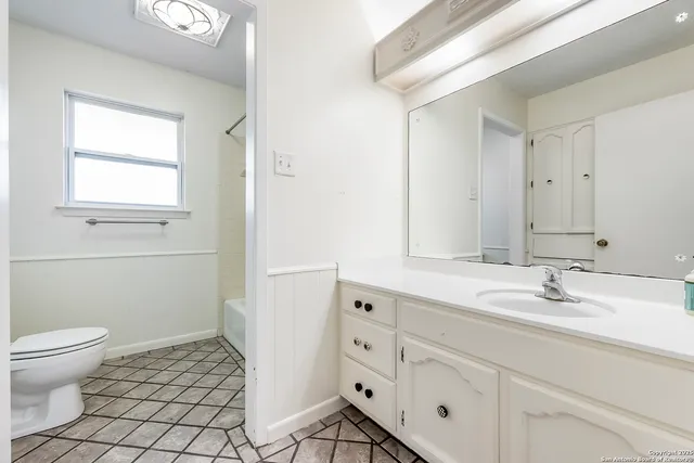 a bathroom with a sink a toilet and a mirror