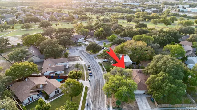 an aerial view of residential houses with outdoor space and trees