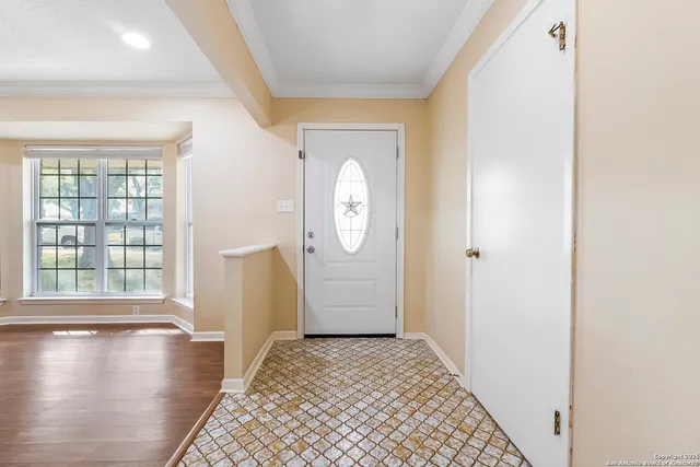 a view of a hallway with wooden floor and a window