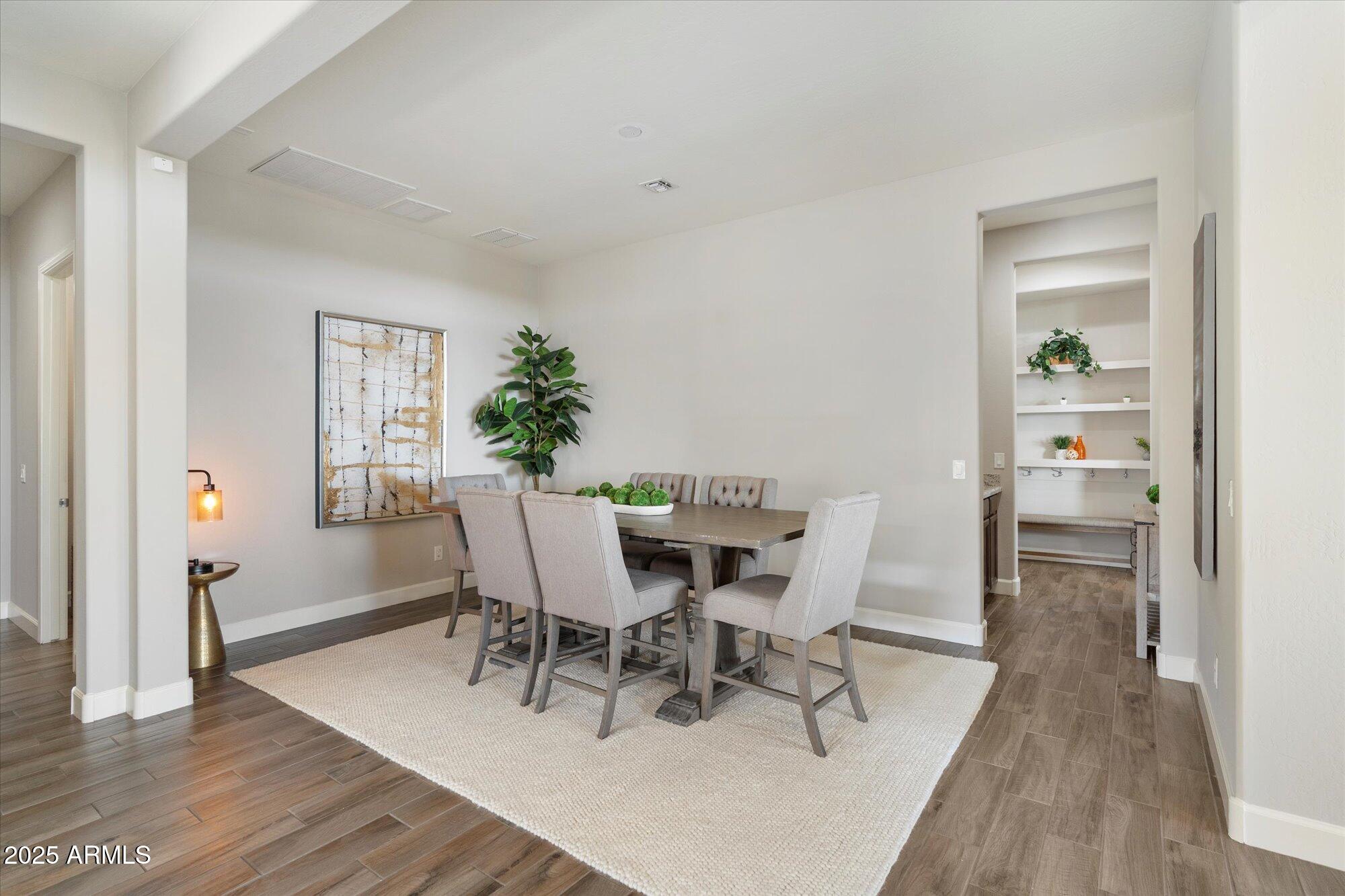 9275 West Plum Road Peoria, AZ 85383 - Photo 12 of 39 a view of a dining room with furniture and wooden floor