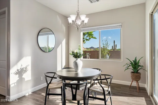 a dining room with furniture a potted plant and wooden floor