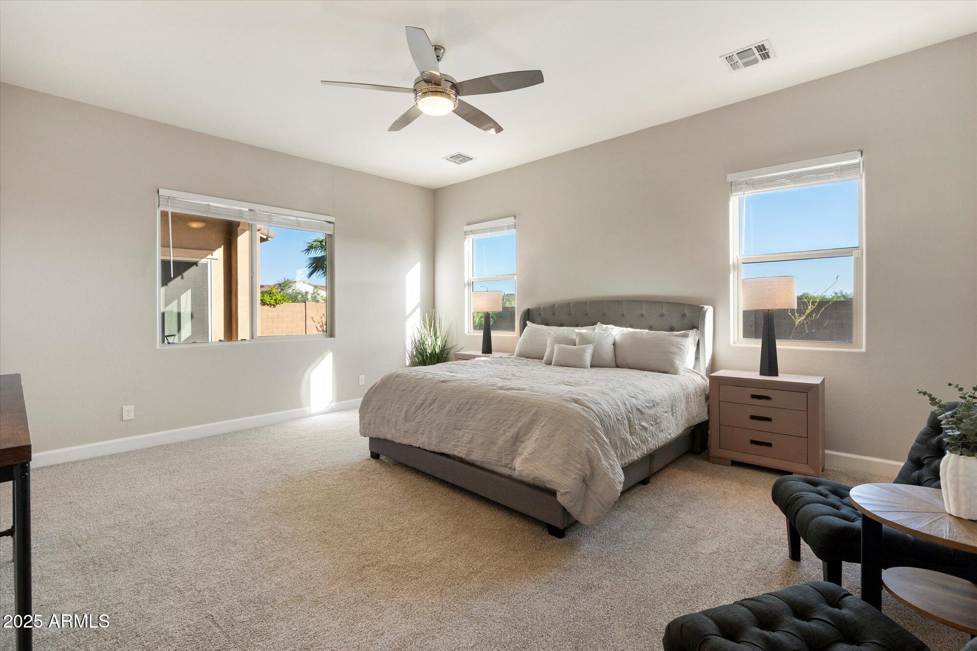 9275 West Plum Road Peoria, AZ 85383 - Photo 16 of 39 a bedroom with a bed and a chandelier