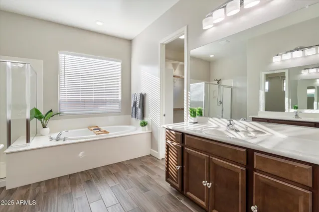 a bathroom with a granite countertop tub a sink and a large mirror