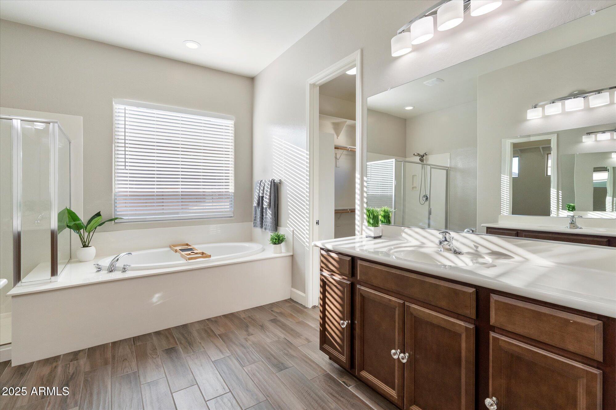 9275 West Plum Road Peoria, AZ 85383 - Photo 19 of 39 a bathroom with a granite countertop tub a sink and a large mirror