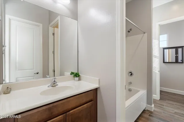 a bathroom with a tub sink and mirror