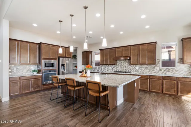 a large kitchen with kitchen island a sink table and chairs
